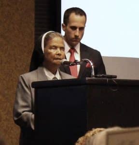 Photo of Sister Linda Pelagio at podium with Meteorologist Chris Vickers in background