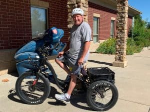 Bill Ludlow seated on his road trike in front of The Sight Center building