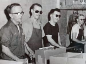 From 1950s 4 men work assembling boxes