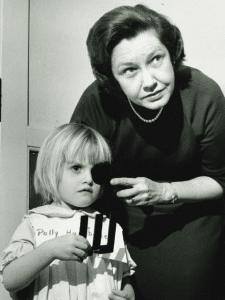 Woman on right testing eyesight of little girl on left.