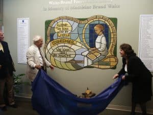 John Davies (left) and Dawn Christensen (right) pull the blue cover sheet off the mosaic.