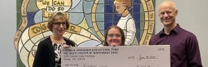 3 people pose with a comically oversized check